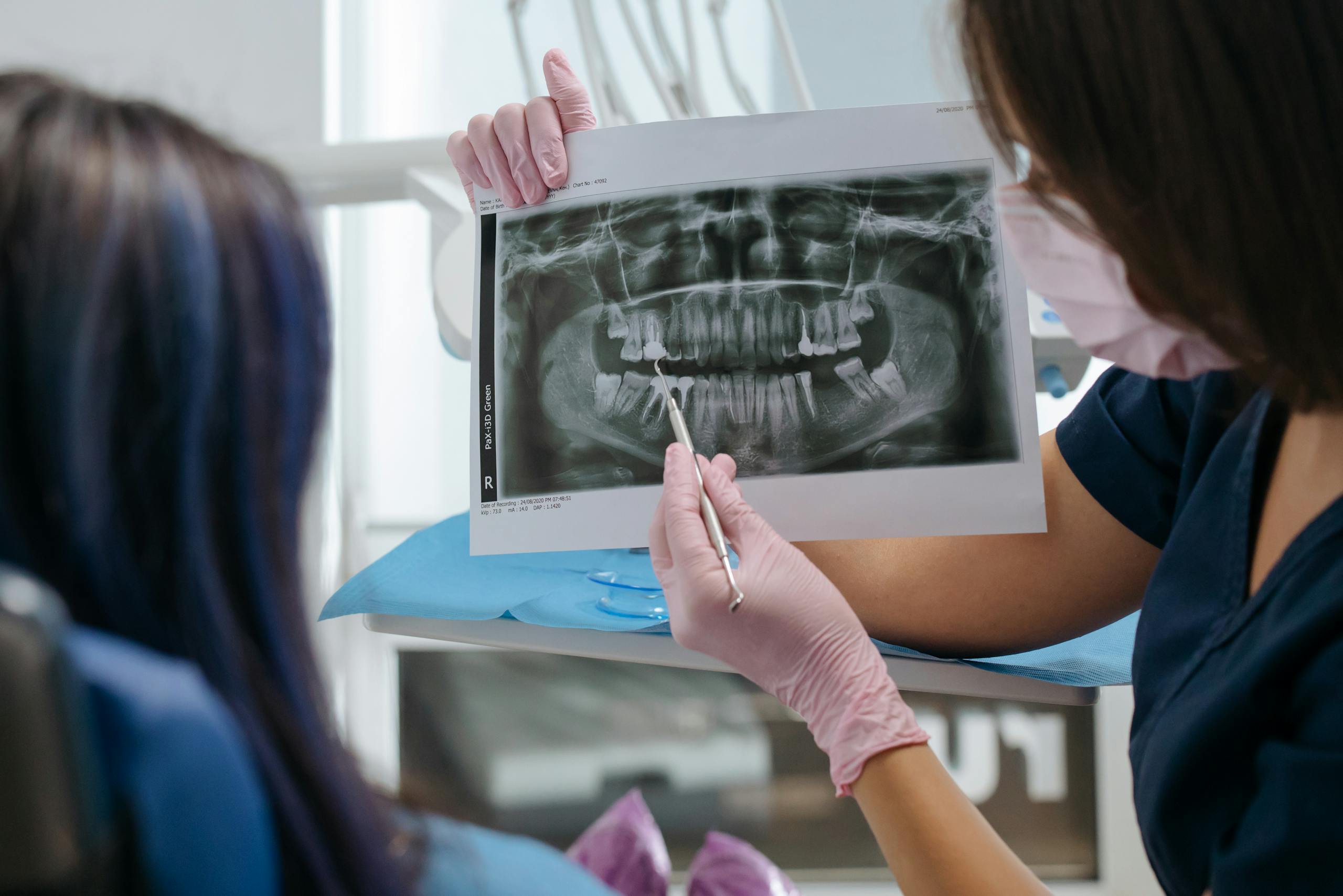 A dentist showing a dental X-ray to a patient, explaining the results and treatment options.